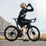 Man in black on road bike refueling and rehydrating with Freak Shake Fuel & Hydrate Electrolyte Replacement